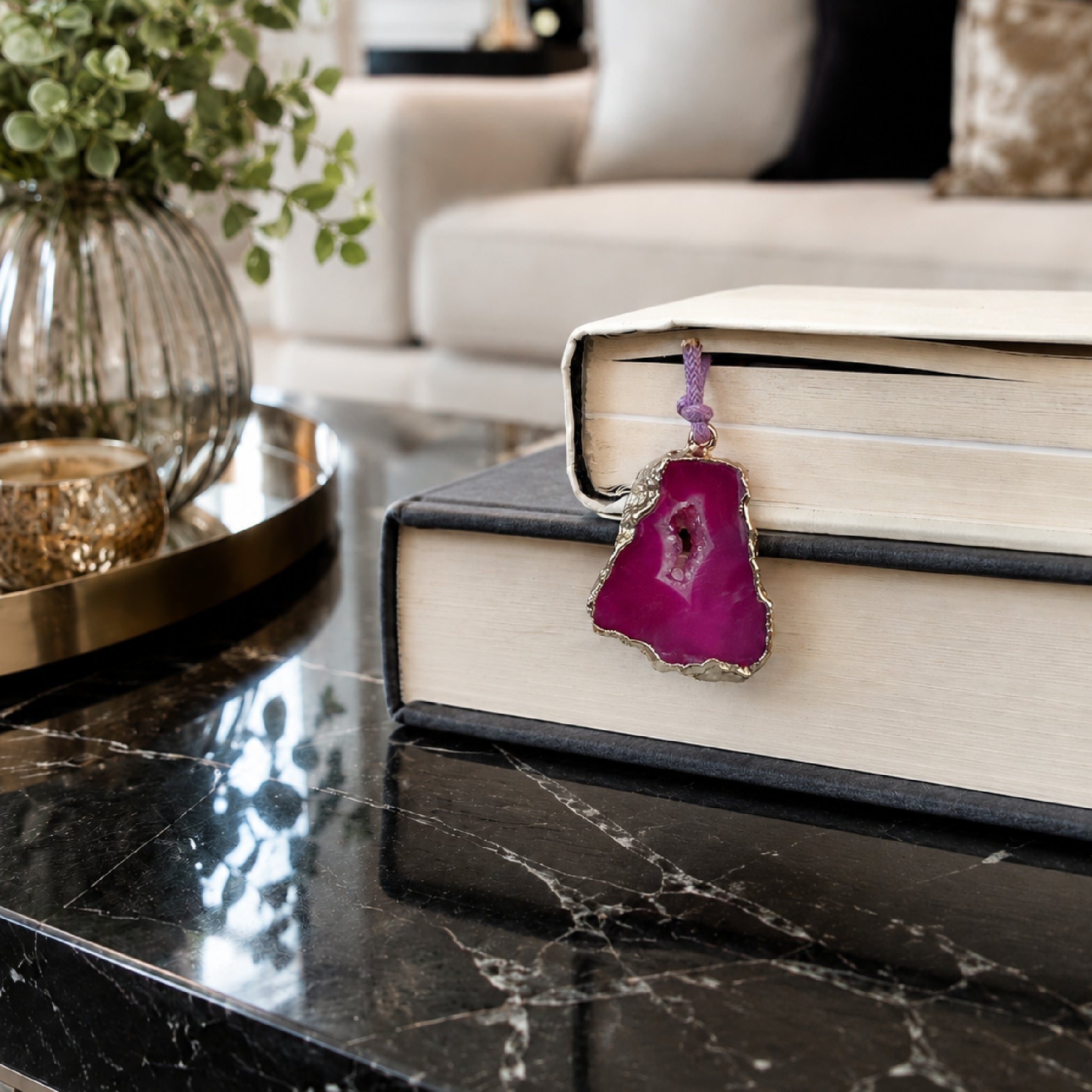 Serra Geode Bookmark – Fuchsia – A handcrafted bookmark by Alysian on a coffee table in a living room.