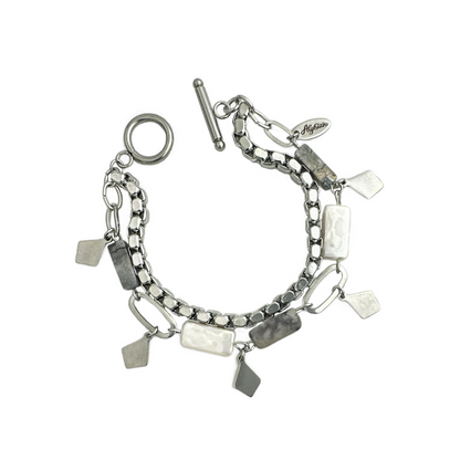 A double strand bracelet with a circular toggle closure, one row of varied stainless steel links, rectangular gray marble stones and shell pearls and geometric stainless steel drops along with a solid strand of sleek stainless steel metal chain.