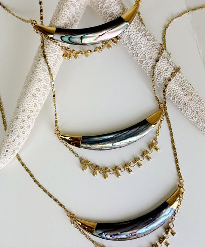 Three Darya abalone pendant necklaces laying against a large starfish. Handcrafted by Alysian.