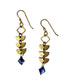 A pair of brass linear Alune Sodalite Earrings with a vertical row of brass geometric shapes and blue sodalite faceted bicone stone drops. Handcrafted by Alysian.