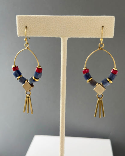 Brass hoop earrings with sodalite and jade stones and geometric brass accents and sleek fringe shown on an earring stand — Azra Sodalite fringe hoop by Alysian.