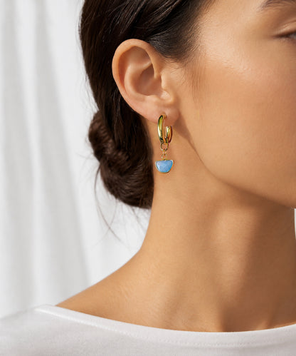 A woman wearing the Charvi Chalcedony Hoop - gold with blue chalcedony semicircle bezel-set stone drops. Handcrafted by Alysian.