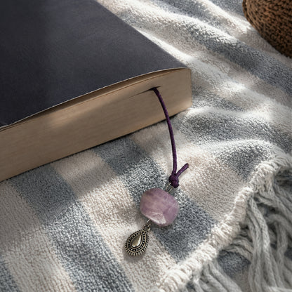 Kyanite stone corded Elira Bookmark in a book on a towel outdoors.