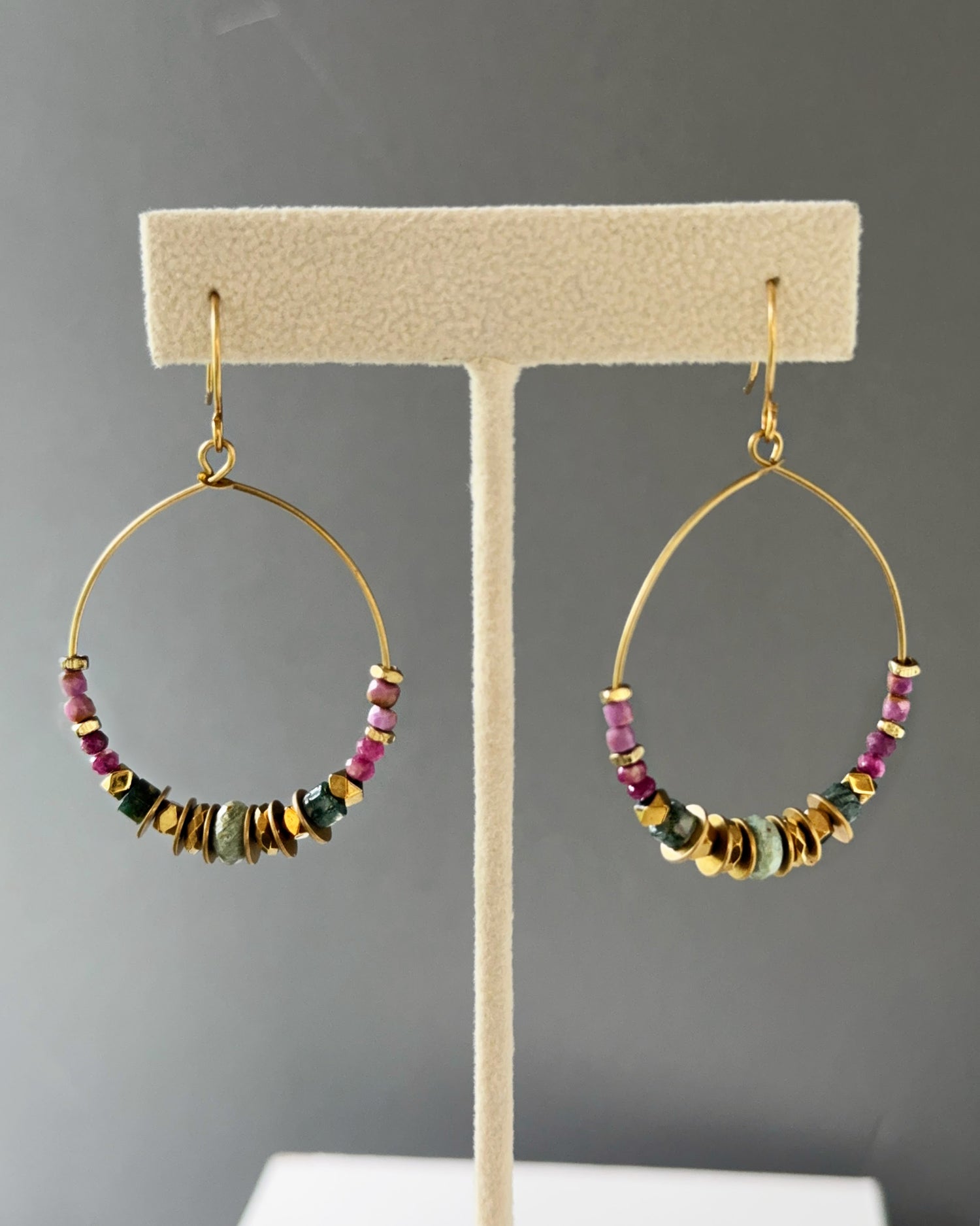Brass hoop earrings with gemstones and edgy brass accents and boho-chic vibes shown on an earring stand — Mirelle Multistone hoop by Alysian.