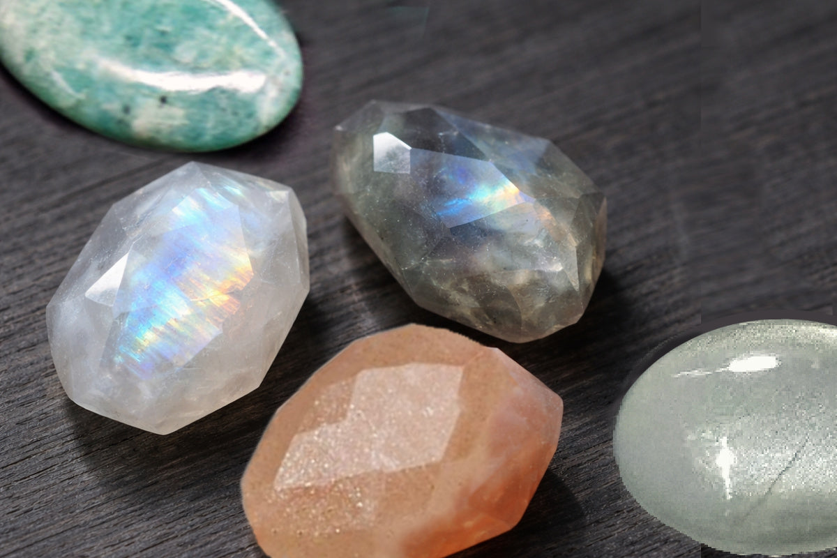 Shimmering feldspar stones including gray, rainbow and peach moonstones, labradorite and amazonite. Each gemstone catches the light. 