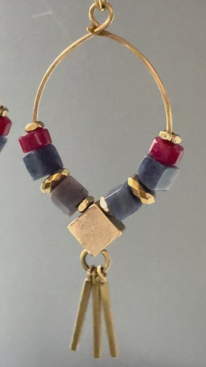 A video of Alysian Azra Sodalite Hoop Earrings close up, with smooth stones and shimmering faceted elements and brass metal fringe. 