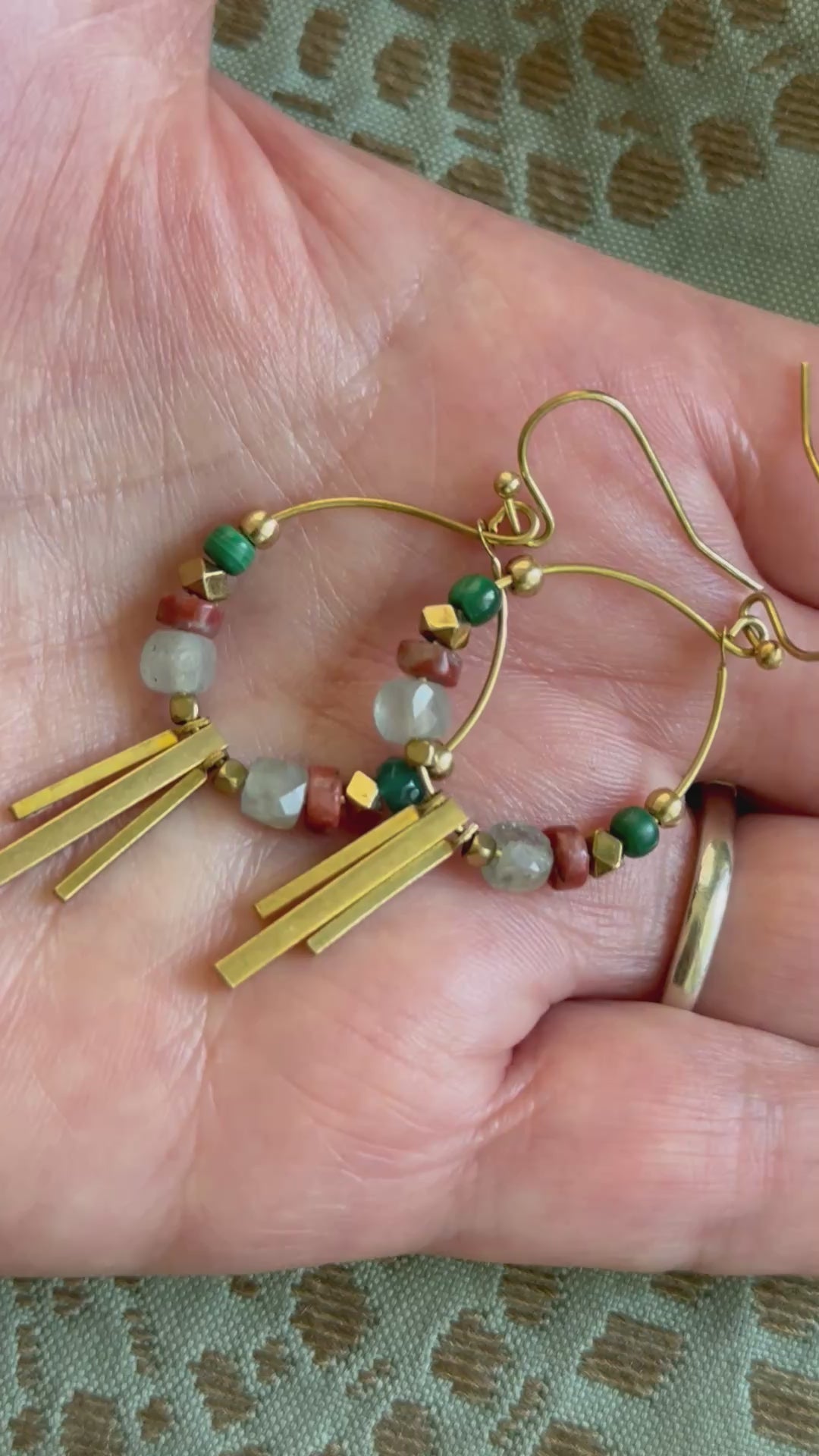Soren apatite and malachite gemstone hoop earring shimmering as it's in a woman's palm to show scale. Handcrafted by Alysian.