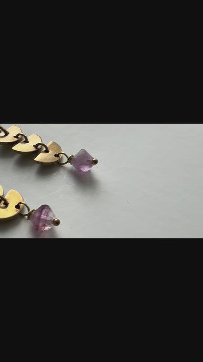 The camera pans across three pairs of brass and gemstone Alune Earrings shown with green fluorite, purple fluorite and sodalite. Handcrafted by Alysian.
