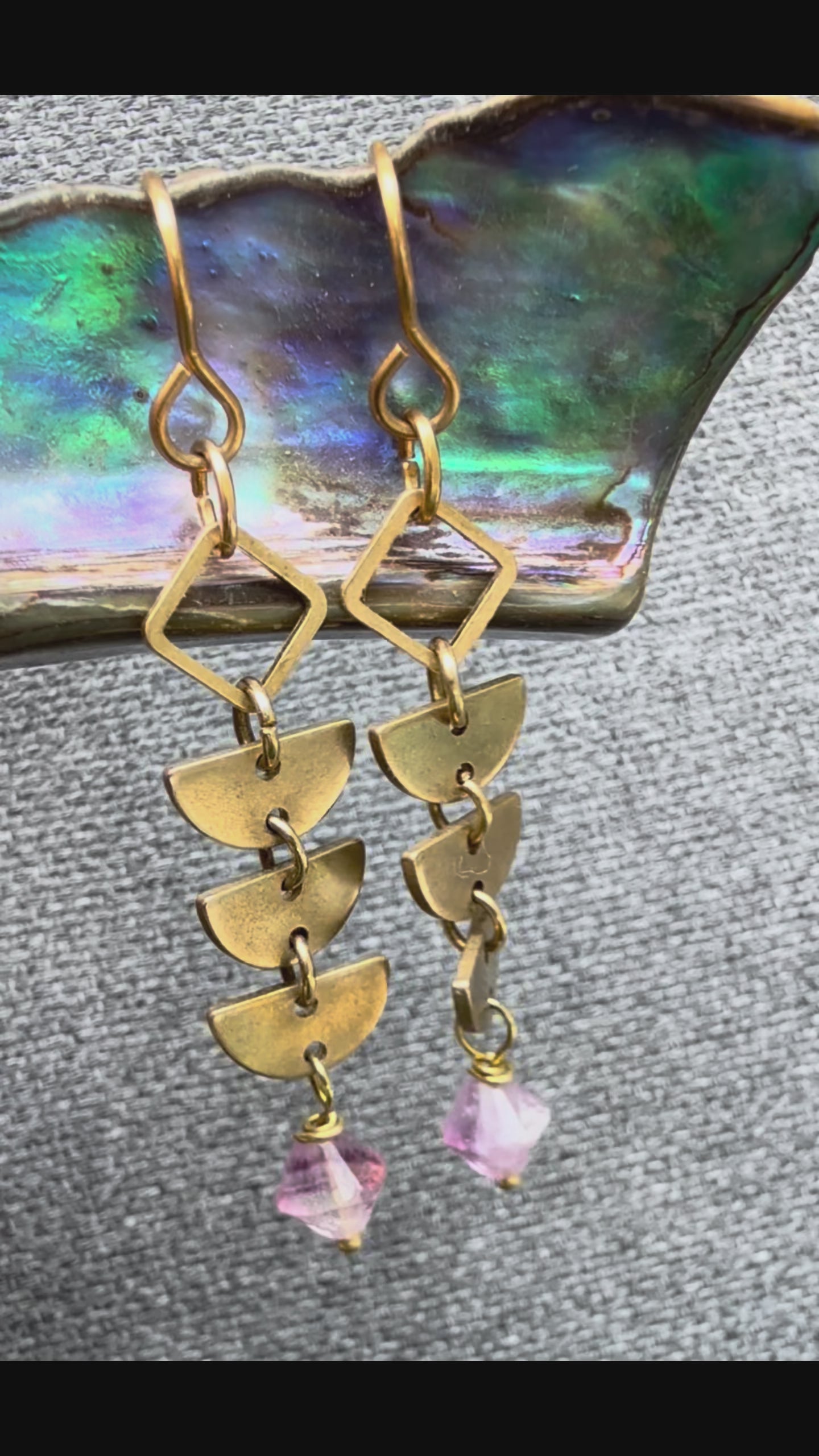Video showing a pairs of brass Alune Fluorite Earrings shown with purple fluorite bicone drops. Handcrafted by Alysian.