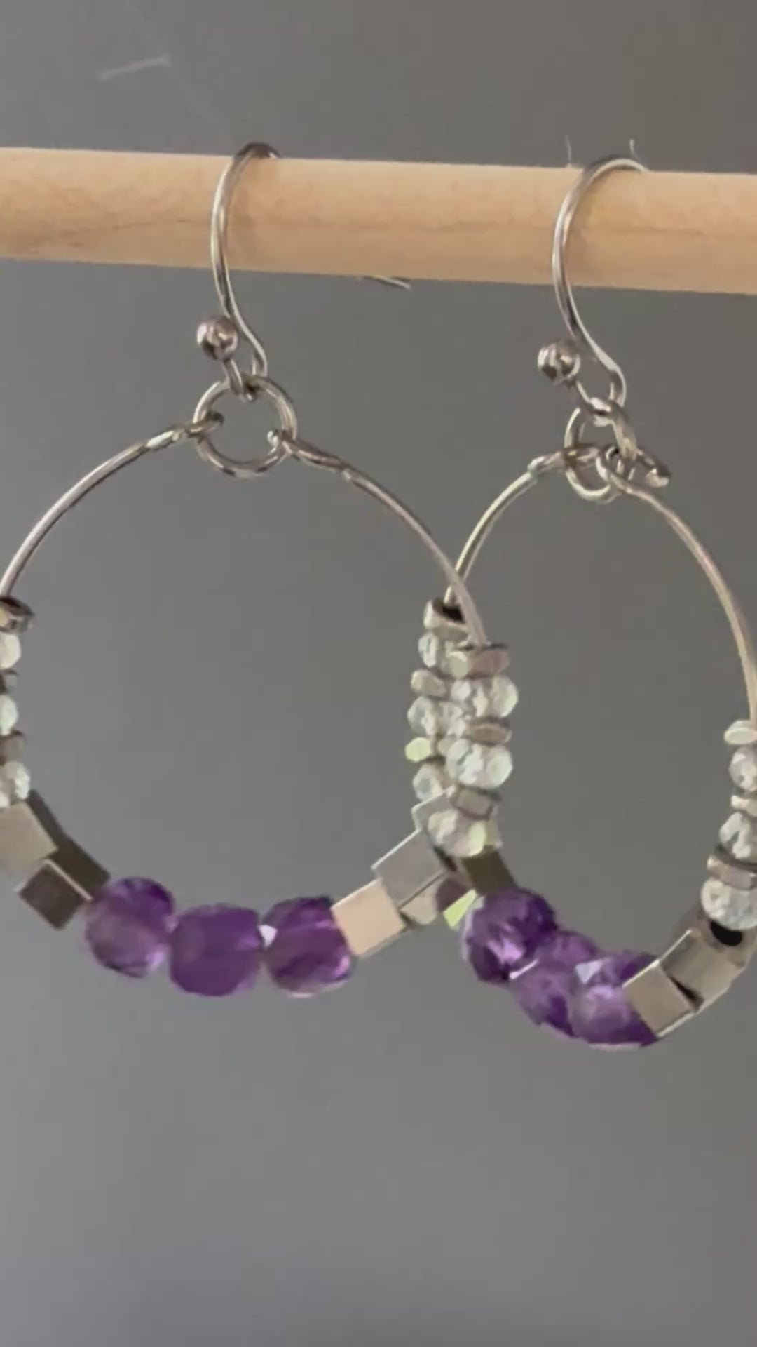 A video of Alysian Luma Amethyst Hoop Earrings close up with gemstones shimmering.
