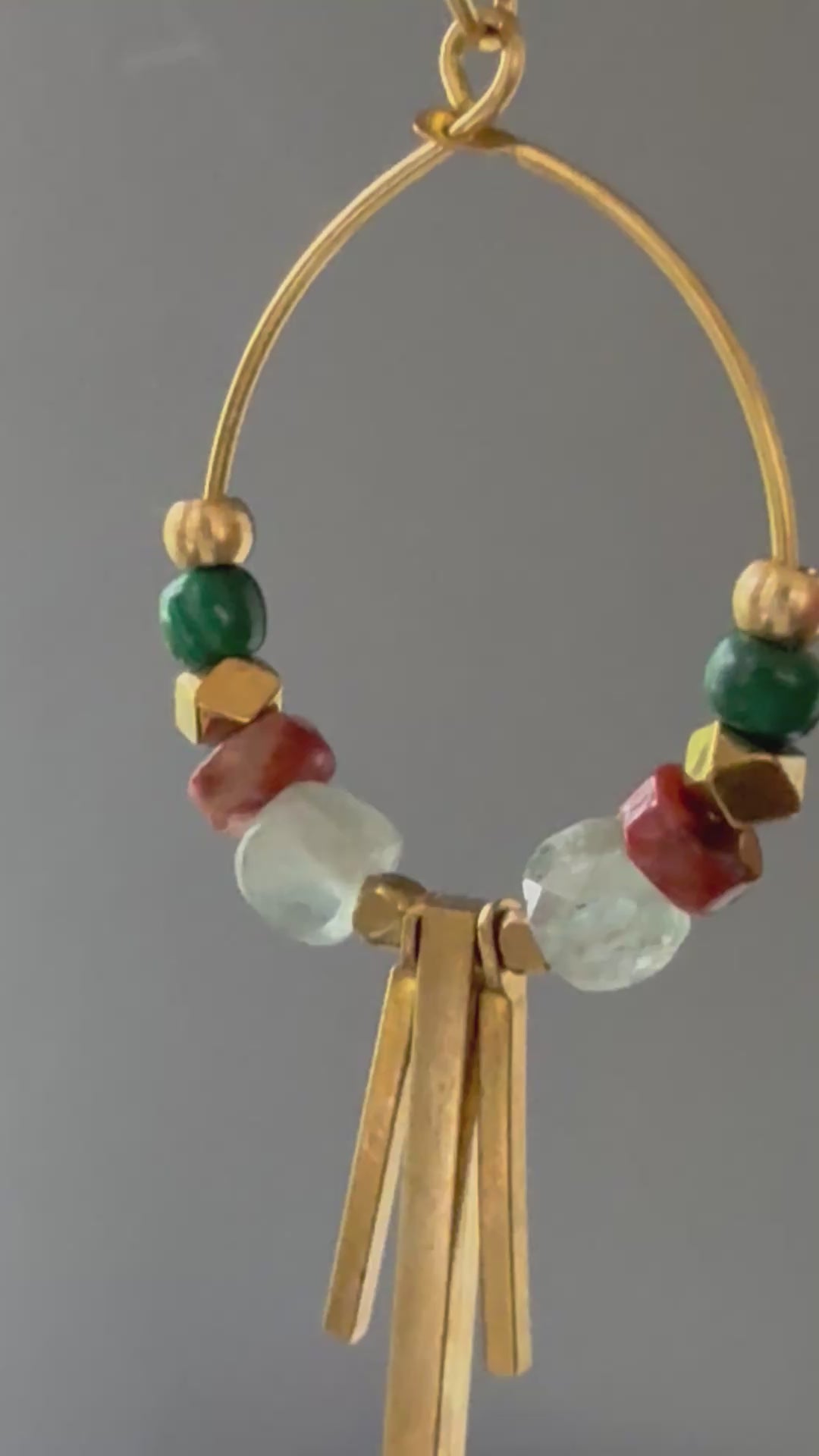 A video of Alysian Soren Apatite Hoop Earrings close up with gemstones and brass accents shimmering.