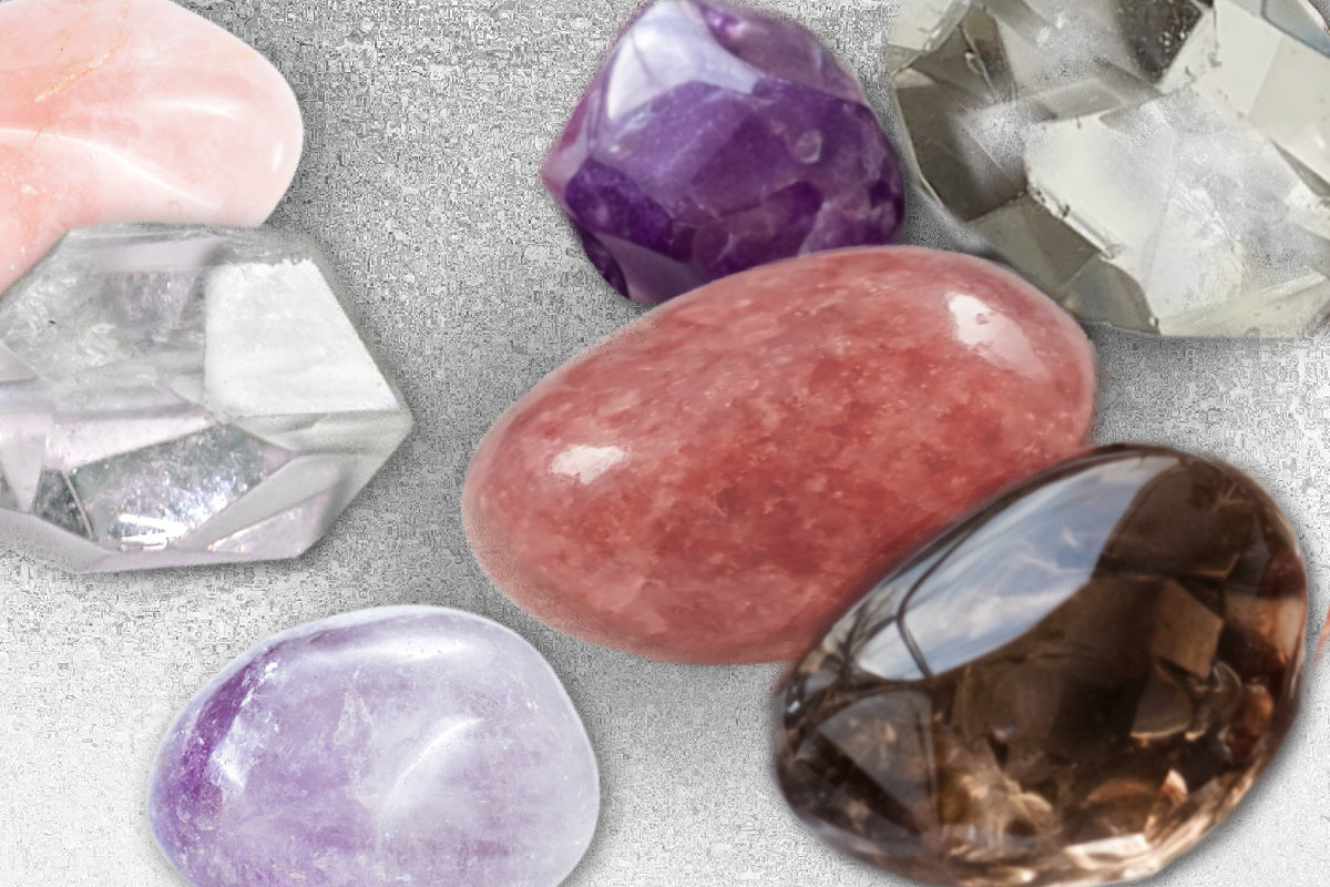 Collection of various core crystals including clear quartz, rose quartz, smoky quartz, ametrine, strawberry quartz and amethyst. Each stone showing natural variations and shine. 